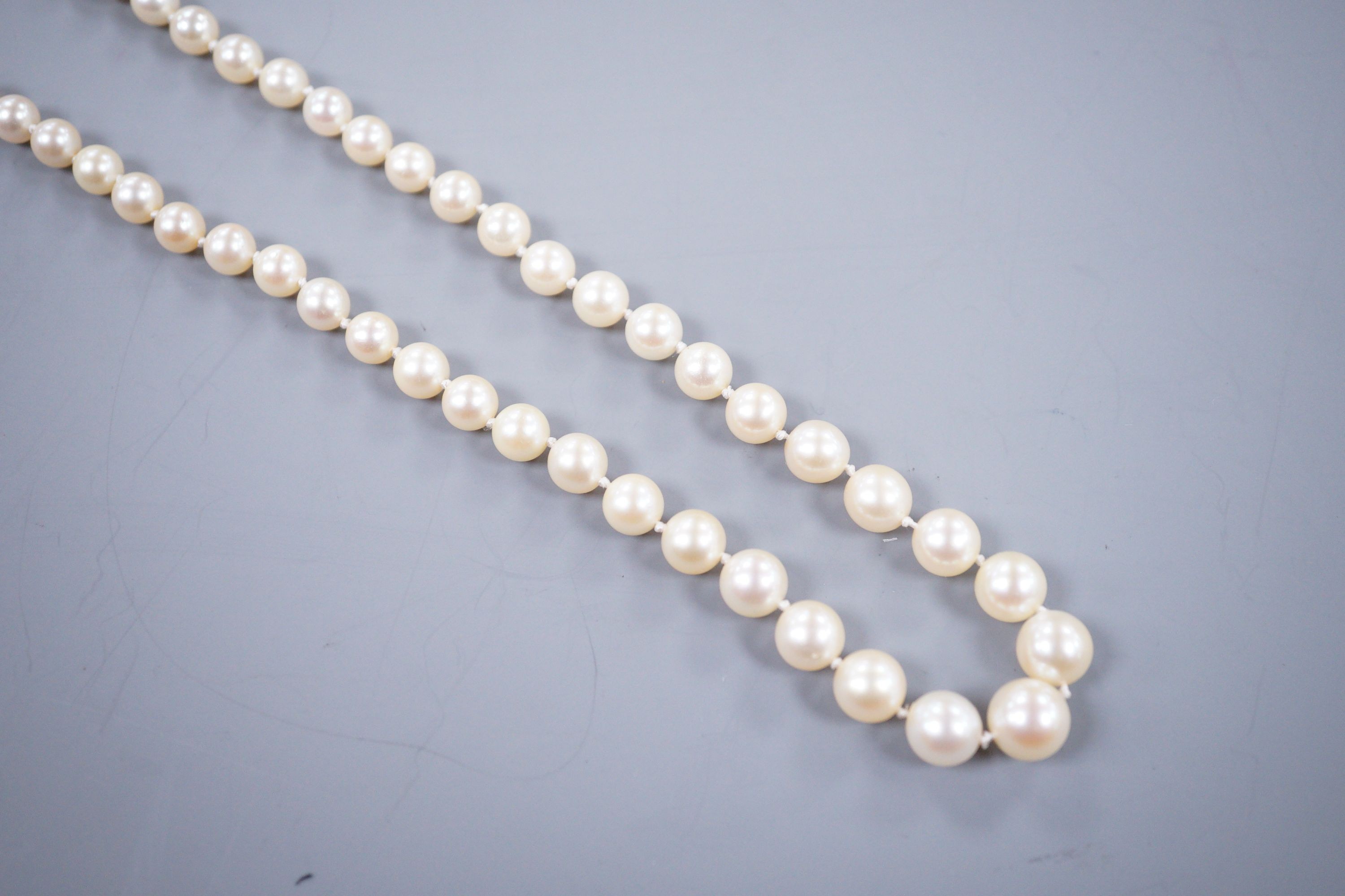 A single strand graduated cultured pearl necklace, with rose cut diamond set yellow metal clasp, 52cm.